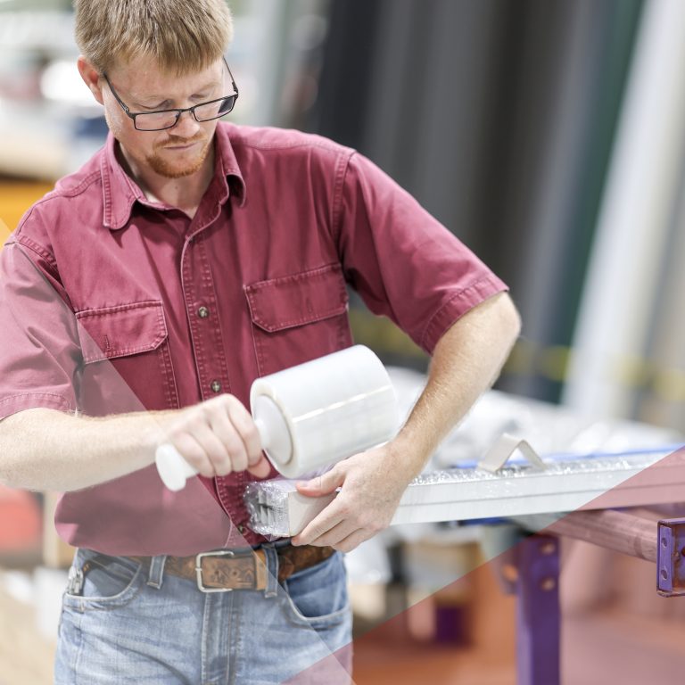 Man wrapping custom trim in shrink wrap